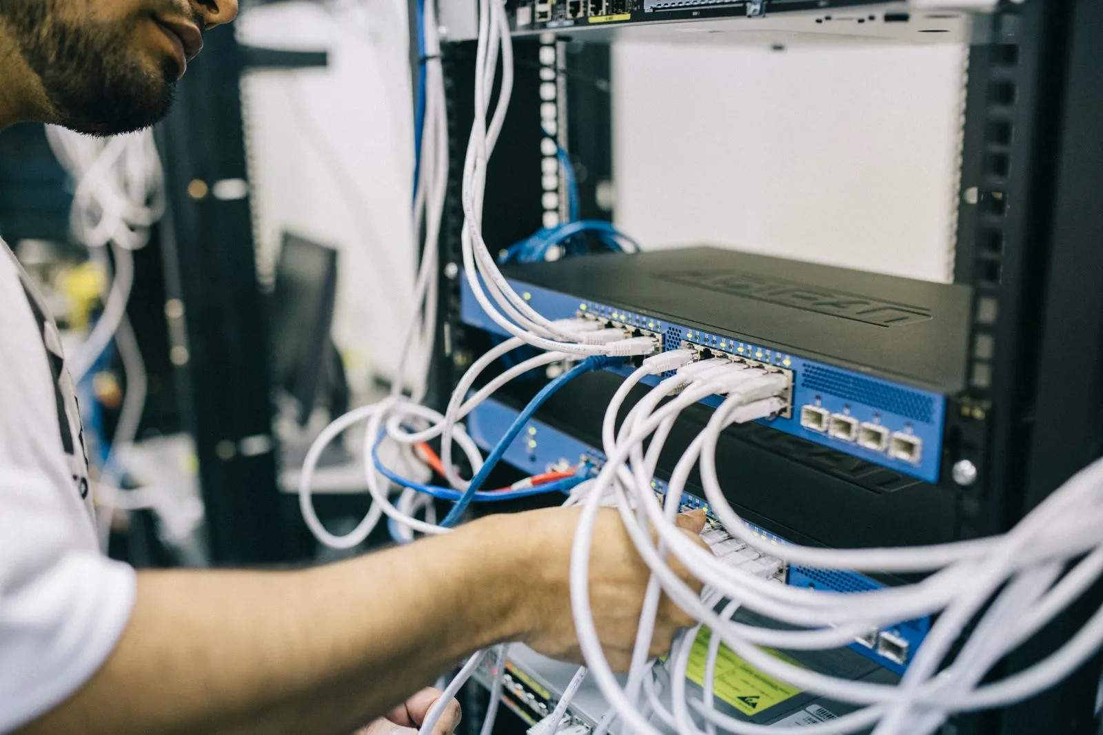 Techniker verkabelt einen Netzwerk-Switch im Serverschrank