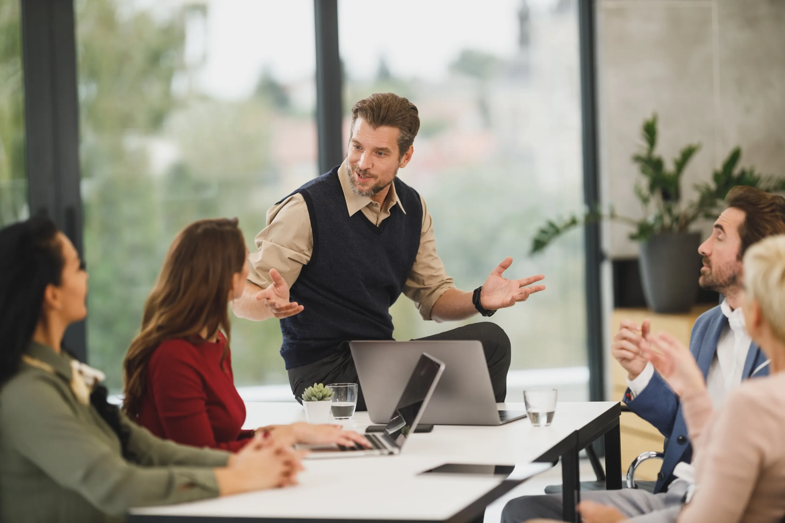IT-Workshop: Trainer erklärt einem Team am Besprechungstisch einen Arbeitsablauf