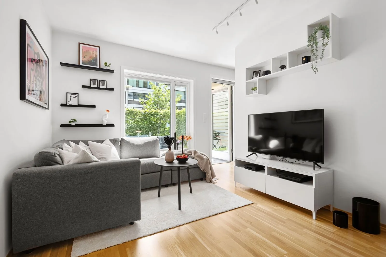 Helles, modernes Wohnzimmer mit Flachbildfernseher auf einem Lowboard