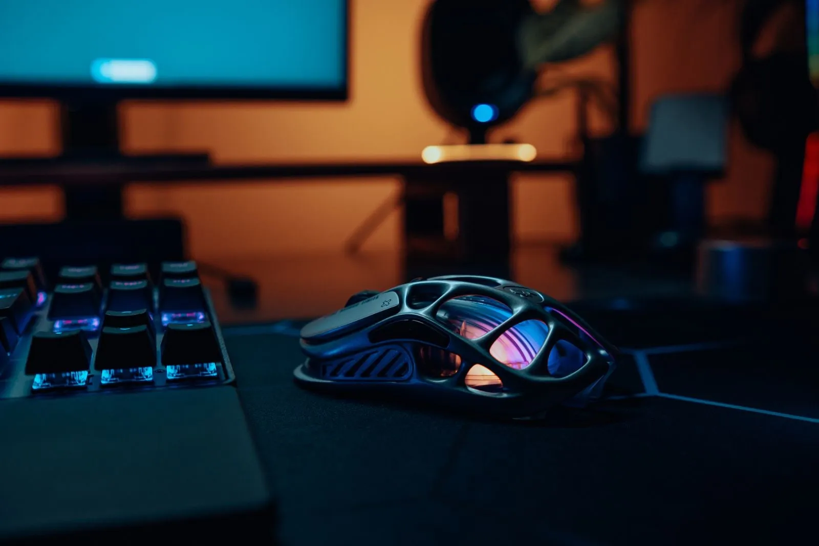 Gaming-Maus mit RGB-Beleuchtung neben einer Tastatur